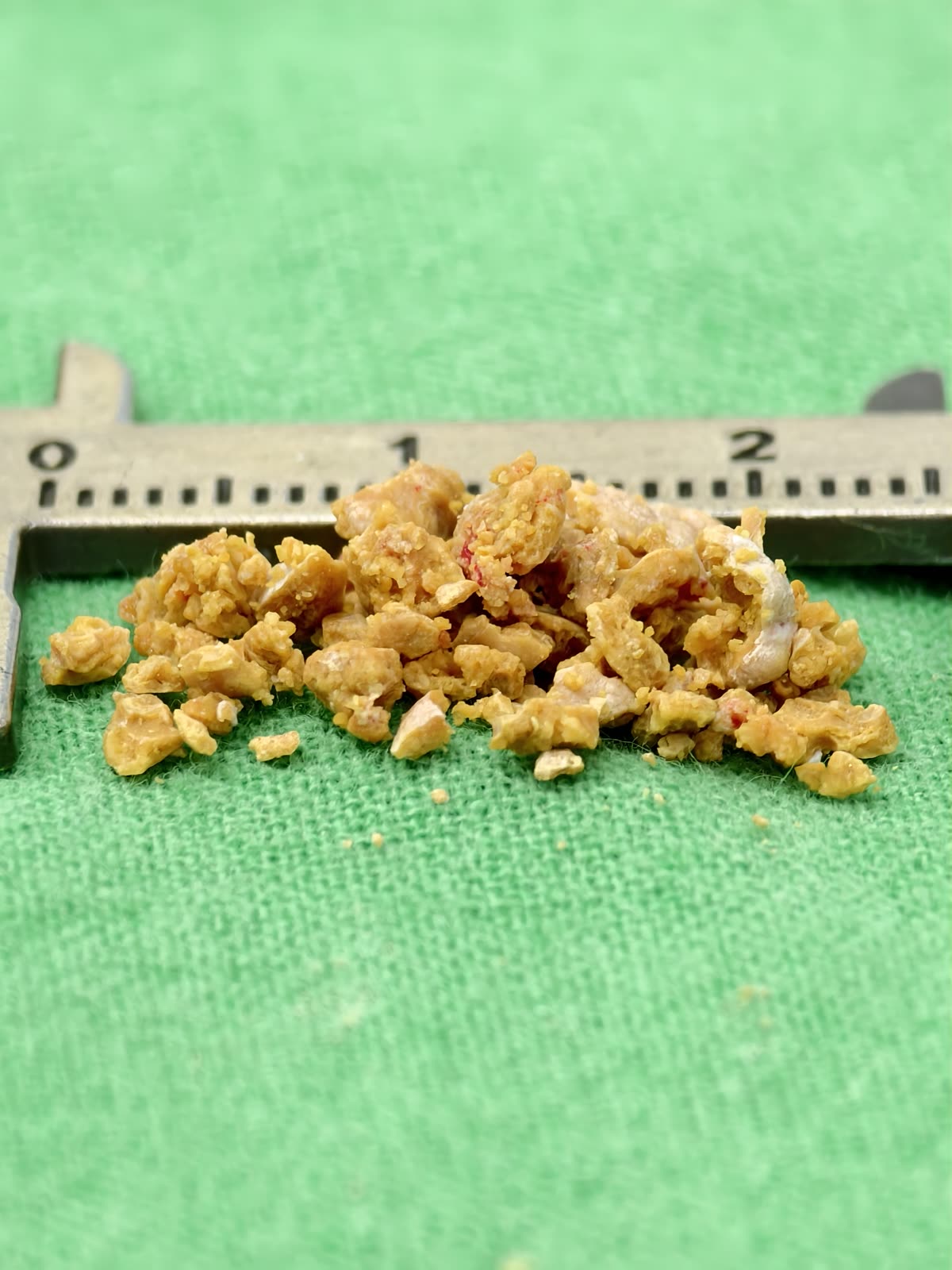 卡尺旁一堆橙黃色的結石碎塊